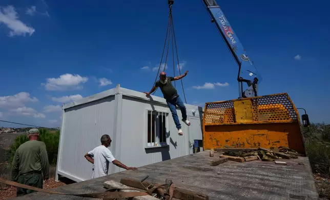 Workers set up a prefabricated unit to provide housing for families whose homes have been destroyed in the fighting between Hezbollah and Israel, in Zawtar al-Gharbieh, southern Lebanon, Monday, Sept. 21, 2026. (AP Photo/Mohammed Zaatari)