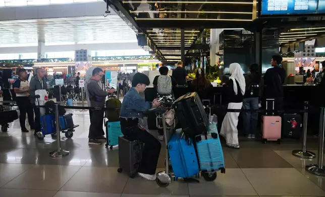 Travelers wait for their flights at Soekarno-Hatta International Airport in Tangerang, Indonesia, Sunday, Sept. 6, 2026. (AP Photo/Tatan Syuflana)