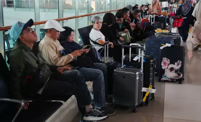Travelers wait for their flights at Soekarno-Hatta International Airport in Tangerang, Indonesia, Sunday, Sept. 6, 2026. (AP Photo/Tatan Syuflana)