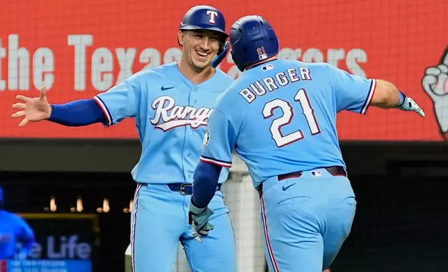Texas Rangers' Wyatt Langford, left, and Jake Burger (21) celebrate Burger's two-run home run that scored Langford during the fourth inning of a baseball game against the Tampa Bay Rays Sunday, Sept. 6, 2026, in Arlington, Texas. (AP Photo/Tony Gutierrez)