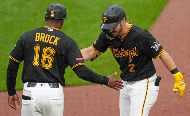 Pittsburgh Pirates' Spencer Horwitz (2) celebrates with first base coach Tarrik Brock (16) after driving in a run with a single off Kansas City Royals pitcher Michael Wacha during the sixth inning of a baseball game in Pittsburgh, Sunday, Sept. 20, 2026. (AP Photo/Gene J. Puskar)