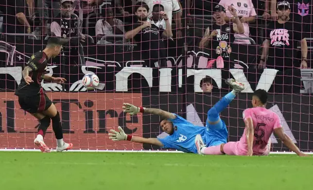 Atlanta United midfielder Miguel Almirón, left scores a goal past Inter Miami goalkeeper Dayne St. Clair, center, during the first half of an MLS soccer match, Saturday, Sept. 5, 2026, in Miami. (AP Photo/Lynne Sladky)