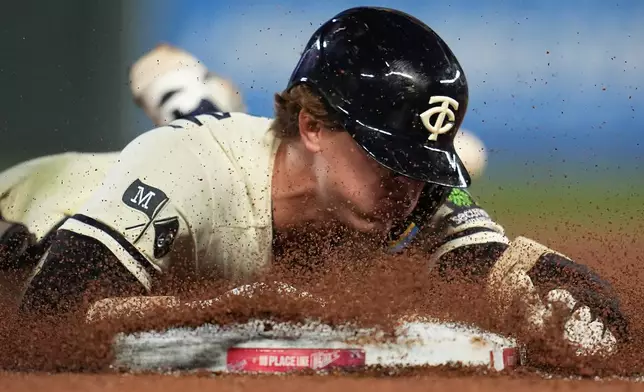 Minnesota Twins' Luke Keaschall dives into third base after hitting a triple during the eighth inning of a baseball game against the Texas Rangers, Saturday, Sept. 26, 2026, in Minneapolis. (AP Photo/Abbie Parr)