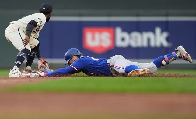 Texas Rangers' Brandon Nimmo dives to reach second base safely after hitting a RBI-double during the second inning of a baseball game against the Minnesota Twins, Saturday, Sept. 26, 2026, in Minneapolis. (AP Photo/Abbie Parr)