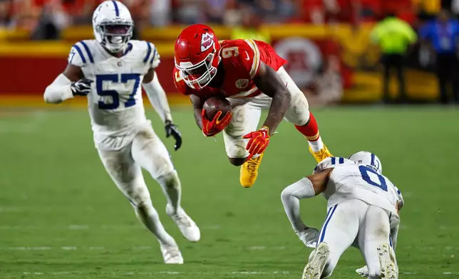 Kansas City Chiefs running back Kenneth Walker III (9) is upended by Indianapolis Colts safety Cam Bynum (0) as Colts linebacker Jaylon Carlies (57) watches during overtime of an NFL football game Sunday, Sept. 20, 2026, in Kansas City, Mo. (AP Photo/Colin E. Braley)