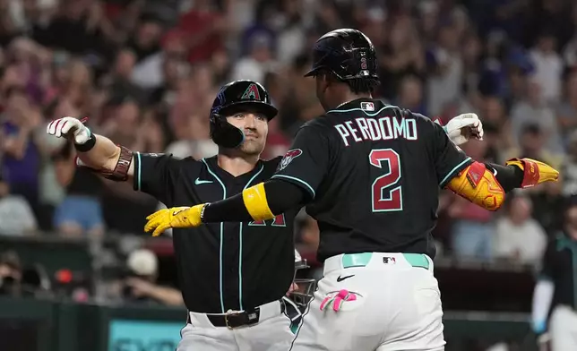 Arizona Diamondbacks' Corbin Carroll, left, celebrates his two-run home run against the New York Yankees with Diamondbacks' Geraldo Perdomo (2) during the second inning of a baseball game, Friday, Sept. 18, 2026, in Phoenix. (AP Photo/Ross D. Franklin)