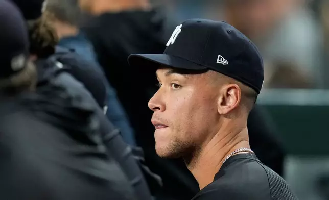 Injured New York Yankees' Aaron Judge sits with teammates in the dugout during the sixth inning of a baseball game against the Arizona Diamondbacks, Friday, Sept. 18, 2026, in Phoenix. (AP Photo/Ross D. Franklin)