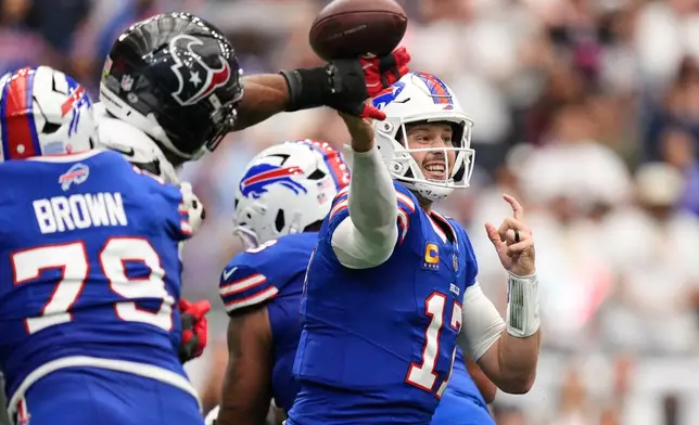 Buffalo Bills quarterback Josh Allen (17) throws an incomplete pass forced by Houston Texans defensive end Danielle Hunter, second from left, during the second half of an NFL football game, Sunday, Sept. 13, 2026, in Houston. (AP Photo/Ashley Landis)