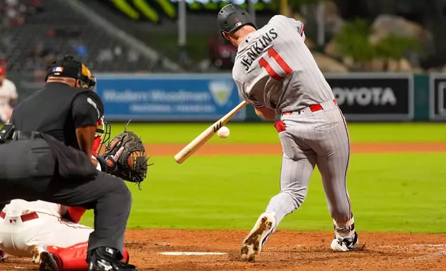 Minnesota Twins' Walker Jenkins, right, hits a two-run home run as Los Angeles Angels catcher Tyler Heineman, center, and home plate umpire Laz Diaz watch during the ninth inning of a baseball game Thursday, Sept. 17, 2026, in Anaheim, Calif. (AP Photo/Mark J. Terrill)