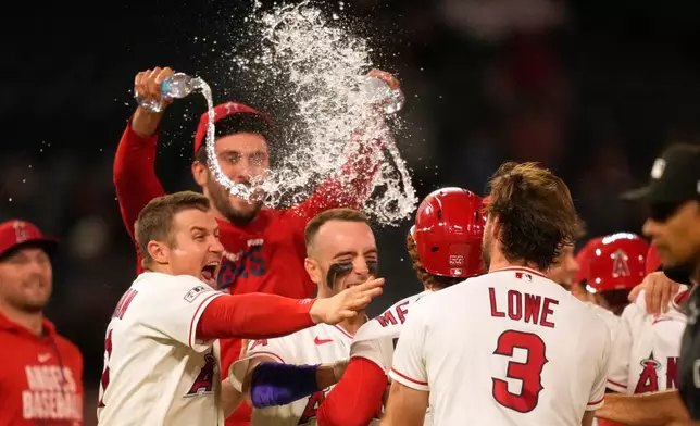Los Angeles Angels' Wade Meckler (53) celebrates his walk-off single with teammates in the 10th inning of a baseball game against the Minnesota Twins, Thursday, Sept. 17, 2026, in Anaheim, Calif. (AP Photo/Mark J. Terrill)