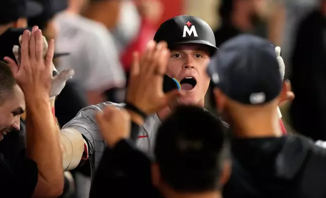 Minnesota Twins' Walker Jenkins is congratulated by teammates in the dugout after hitting a two-run home run during the ninth inning of a baseball game against the Los Angeles Angels, Thursday, Sept. 17, 2026, in Anaheim, Calif. (AP Photo/Mark J. Terrill)
