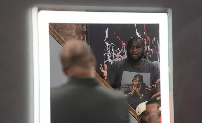 Stanley Thigpen, reflected in a barber shop mirror at Philly Cuts in Philadelphia, speaks, Friday, Aug. 21, 2026, during a discussion facilitated by Win With Black Men. (AP Photo/Matt Rourke)