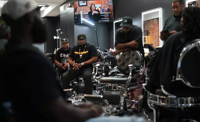 A video with former Vice President Kamala Harris plays in the background at Philly Cuts in Philadelphia, Friday, Aug. 21, 2026, during a discussion facilitated by Win With Black Men. (AP Photo/Matt Rourke)