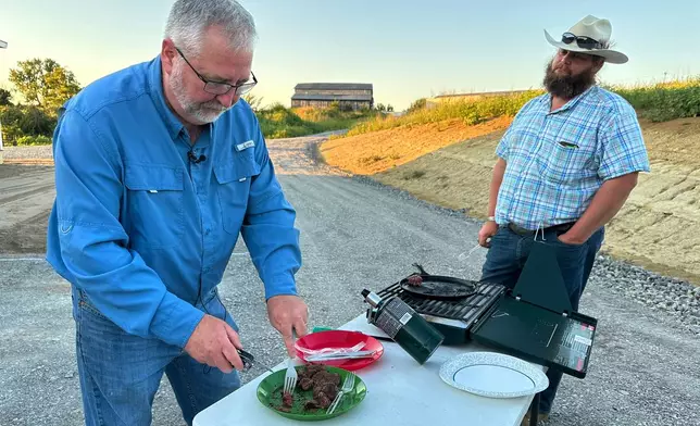 In this photo taken with a smartphone, Brent Williams, an alpha gal syndrome sufferer, prepares ostrich meat with farm owner W.D. King in Danville, Ky., on Tuesday, Aug. 18, 2026. (AP Photo/Dylan Lovan)