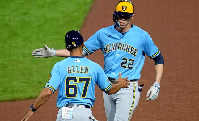 Milwaukee Brewers' Christian Yelich (22) celebrates with first base coach Spencer Allen after driving in two runs with a single off Pittsburgh Pirates pitcher Carmen Mlodzinski during the seventh inning of a baseball game in Pittsburgh, Wednesday, Sept. 16, 2026. (AP Photo/Gene J. Puskar)