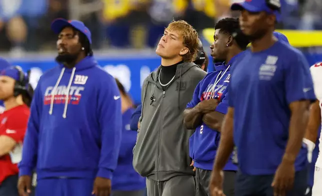 New York Giants quarterback Jaxson Dart, center, watches from the sideline during the second half of an NFL football game against the Los Angeles Rams in Inglewood, Calif., Monday, Sept. 21, 2026. (AP Photo/Caroline Brehman)