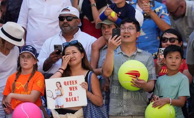 Fans react to Qinwen Zheng, of China, winning a match against Iga Swiatek, of Poland, during the fourth round of the U.S. Open tennis championships, Monday, Sept. 7, 2026, in New York. (AP Photo/Seth Wenig)