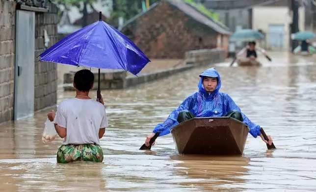 Local residents commute by boat through a flooded village on the outskirts of Hanoi, Vietnam Thursday, Sep. 17, 2026. (Pham Tuan Anh/VNA via AP)