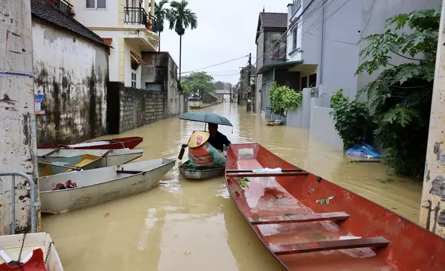 Local residents commute by boat through a flooded village on the outskirts of Hanoi, Vietnam Thursday, Sep. 17, 2026. (Nhat Anh/VNA via AP)