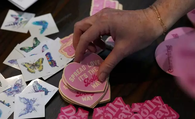 Stickers are seen during a Dolly Parton Day event to honor the late country music artist, Friday, Sept. 25, 2026, in Nashville, Tenn. (AP Photo/George Walker IV)