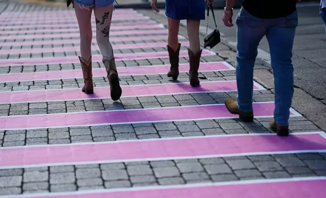 People make their way across a pink crosswalk during Dolly Parton Day honoring the late country music artist Friday, Sept. 25, 2026, in Nashville, Tenn. (AP Photo/George Walker IV)