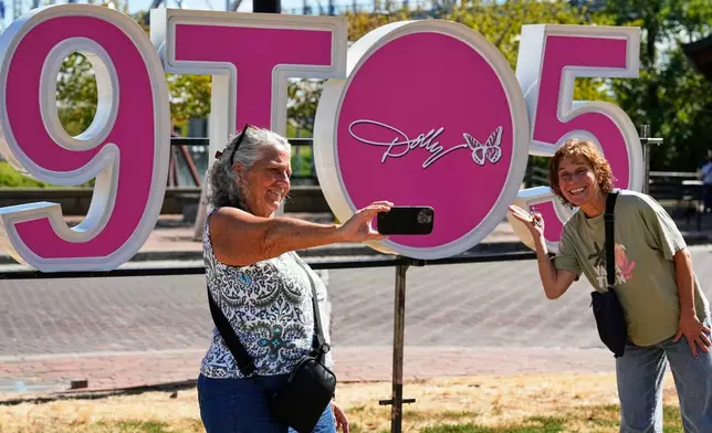 Wendy Delehanty, left, and Nancy Beaty of Jew Jersey pose with a sign during Dolly Parton Day honoring the late country music artist, Friday, Sept. 25, 2026, in Nashville, Tenn. (AP Photo/George Walker IV)
