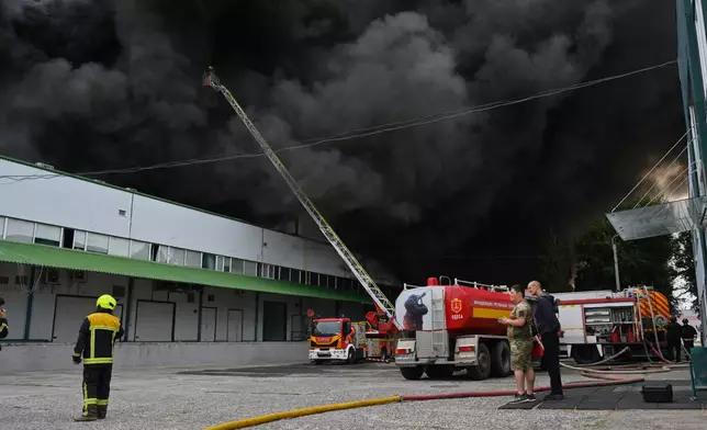 Firefighters put out a fire at warehouse stores after a Russian air attack in Odesa, Ukraine, Sunday, Sept. 13, 2026. (AP Photo/Michael Shtekel)