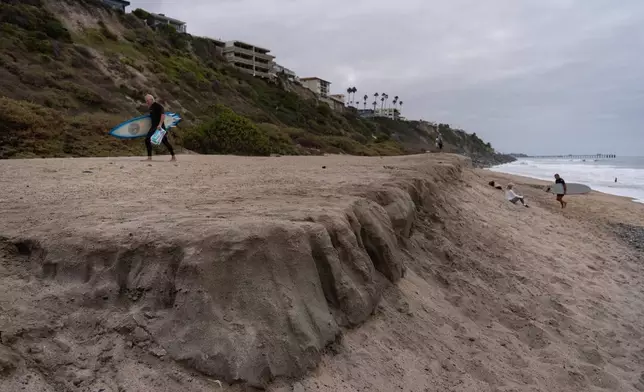 Surfers walk along North Beach in San Clemente, Calif., Friday, Sept. 18, 2026. (AP Photo/Jae C. Hong)