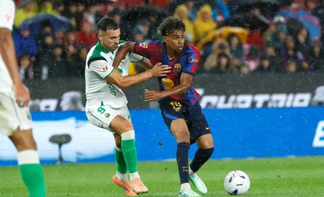 Racing's Juan Carlos Arana vies for the ball with Barcelona's Lamine Yamal, right, during a Spanish La Liga soccer match between Barcelona and Racing de Santander in Barcelona, Spain, Wednesday, Sept. 16, 2026. (AP Photo/Joan Monfort)