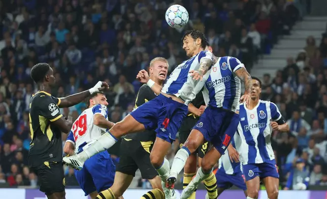 Porto's Jakub Kiwior, center right, jumps for the ball in front of Manchester City's Erling Haaland, center, during a Champions League opening phase soccer match between FC Porto and Manchester City in Porto, Portugal, Tuesday, Sept. 8, 2026. (AP Photo/Luis Vieira)