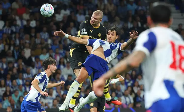 Manchester City's Erling Haaland attempts a header at goal above Porto's Jakub Kiwior during a Champions League opening phase soccer match between FC Porto and Manchester City in Porto, Portugal, Tuesday, Sept. 8, 2026. (AP Photo/Luis Vieira)