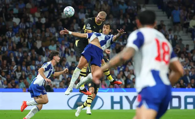 Manchester City's Erling Haaland attempts a header at goal above Porto's Jakub Kiwior during a Champions League opening phase soccer match between FC Porto and Manchester City in Porto, Portugal, Tuesday, Sept. 8, 2026. (AP Photo/Luis Vieira)