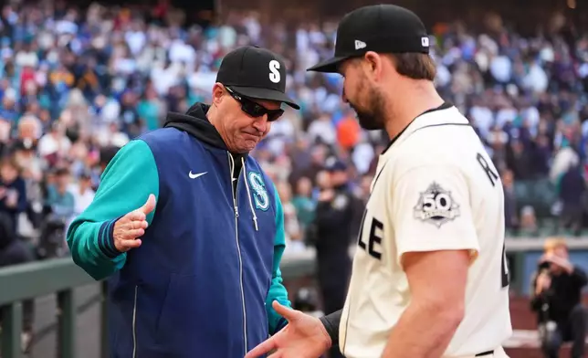 Seattle Mariners manager Dan Wilson greets Cal Raleigh, right, after a win over the Los Angeles Angels in a baseball game, Sunday, Sept. 27, 2026, in Seattle. (AP Photo/Lindsey Wasson)