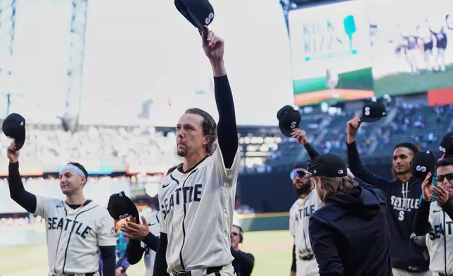 Seattle Mariners players, including starting pitcher Logan Gilbert, walk out to the field to tip their caps to Mariners radio play-by-play announcer Rick Rizzs before the last game of his career before a baseball game against the Los Angeles Angels, Sunday, Sept. 27, 2026, in Seattle. (AP Photo/Lindsey Wasson)