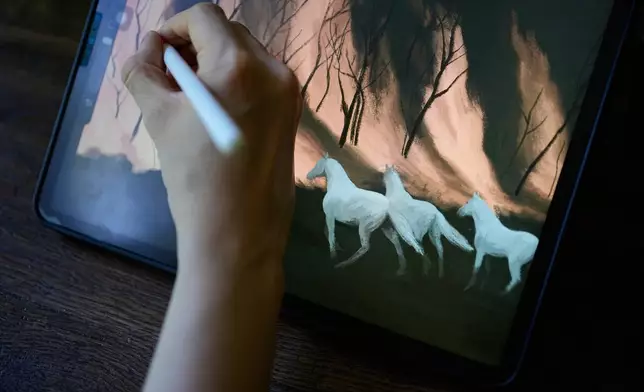 Illustrator Marina Antonova works on a drawing for her series called "Chronicles of a Heating Planet" in Beaumont-les-Valence, southern France, on Sept. 12, 2026. (AP Photo/Laurent Cipriani)