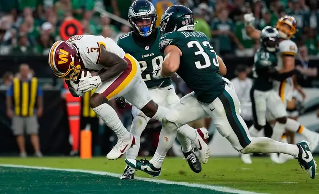 Washington Commanders wide receiver Stefon Diggs (3) scores a touchdown past Philadelphia Eagles cornerback Cooper DeJean (33) and safety Marcus Epps (29) during the second half of an NFL football game, Sunday, Sept. 13, 2026, in Philadelphia. (AP Photo/Matt Slocum)