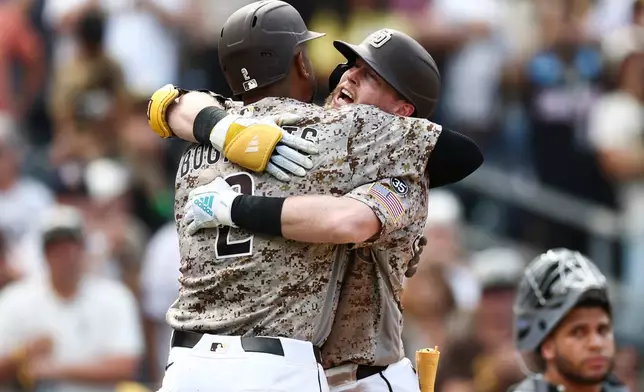 San Diego Padres' Jake Cronenworth, second from left, celebrates after his two-run home run with Xander Bogaerts, left, in the eighth inning of a baseball game against the Miami Marlins, Sunday, Sept. 20, 2026, in San Diego. (AP Photo/Karl Anderson)