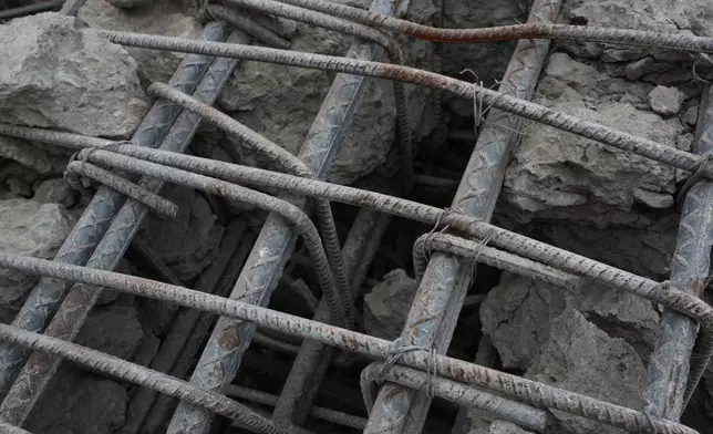 FILE - The rebar cage of a collapsed column is exposed at an O-P-P housing tower that was built as part of a government program, after it fell during twin earthquakes in La Guaira, Venezuela, July 22, 2026. (AP Photo/Ariana Cubillos, File)