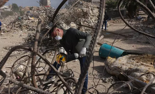 FILE - A worker cuts rebar from an an O-P-P housing tower that was built as part of a government program, and collapsed during twin earthquakes in La Guaira, Venezuela, July 25, 2026. (AP Photo/Pedro Mattey, File)