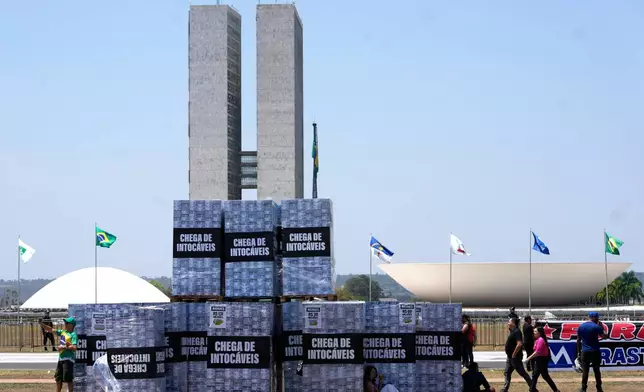 Boxes symbolizing money are displayed outside Congress to protest alleged corruption in the Supreme Court during a protest by supporters of presidential candidate Sen. Flavio Bolsonaro calling for the impeachment of Supreme Court Justice Alexandre de Moraes in Brasilia, Brazil, Tuesday, Sept. 15, 2026. (AP Photo/Eraldo Peres)