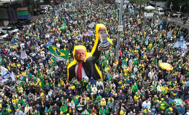 Supporters of opposition presidential candidate Flavio Bolsonaro march with an effigy of U.S. President Donald Trump holding a doll depicting Brazilian President Luiz Inacio Lula da Silva as a prisoner, during an Independence Day event in Sao Paulo, Brazil, Monday, Sept. 7, 2026, the month before the general election. (AP Photo/Andre Penner)
