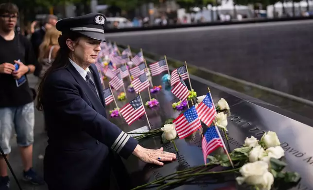 American Airlines pilot Laura Joyce-Hubbard, 59, who was a pilot on 9/11, touches a name on the 9/11 Memorial, Thursday, September 10, 2026 in New York. (AP Photo/Adam Gray)