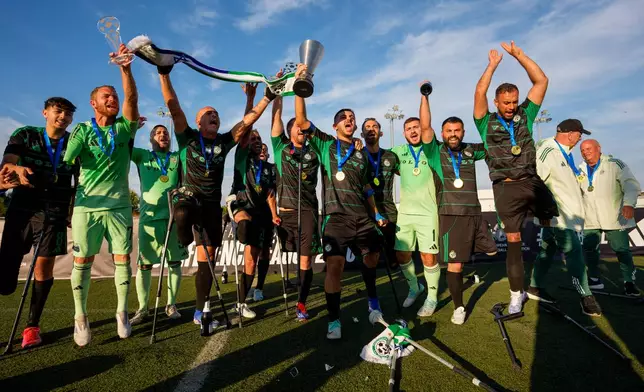 Maccabi Haifa's players celebrate with the trophy during the medal ceremony at the end of the amputee soccer inaugural EAFF Conference League in Bucharest, Romania, Friday, Sept. 25, 2026. (AP Photo/Andreea Alexandru)