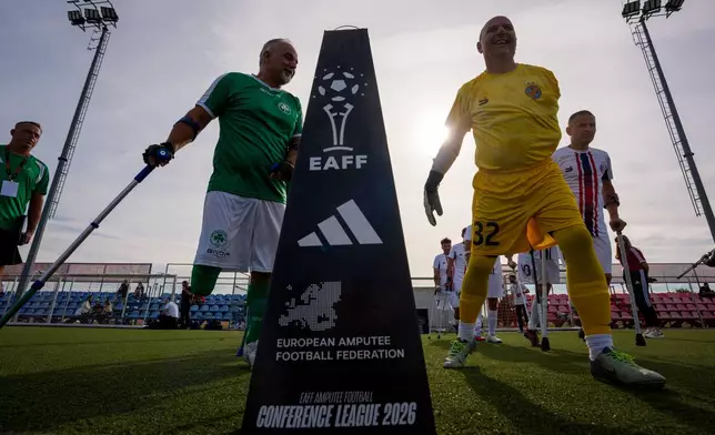 Players enter the pitch before an amputee soccer match between FCSB and Panathinaikos in the inaugural EAFF Conference League in Bucharest, Romania, Friday, Sept. 25, 2026. (AP Photo/Andreea Alexandru)