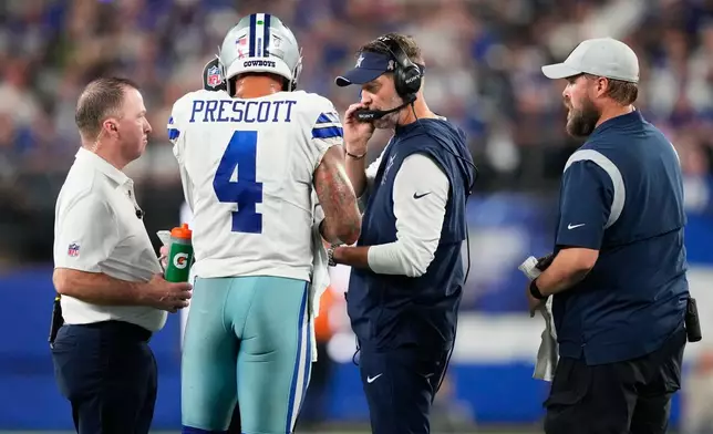 Dallas Cowboys quarterback Dak Prescott (4) talks to head coach Brian Schottenheimer during the first half of an NFL football game against the New York Giants, Sunday, Sept. 13, 2026, in East Rutherford, N.J. (AP Photo/Yuki Iwamura)
