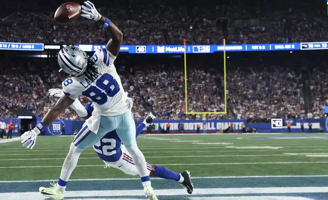 Dallas Cowboys wide receiver Ceedee Lamb (88) tries to pull a catch against New York Giants defensive back Andru Phillips during the second half of an NFL football game Sunday, Sept. 13, 2026, in East Rutherford, N.J. (AP Photo/Pamela Smith)