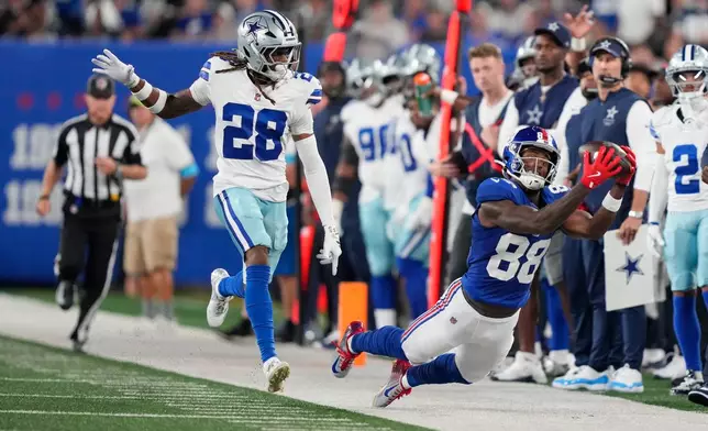 New York Giants wide receiver Malachi Fields (88) attempts but is unable to make a catch in front of Dallas Cowboys cornerback Shavon Revel Jr. (28) during the first half of an NFL football game Sunday, Sept. 13, 2026, in East Rutherford, N.J. (AP Photo/Yuki Iwamura)