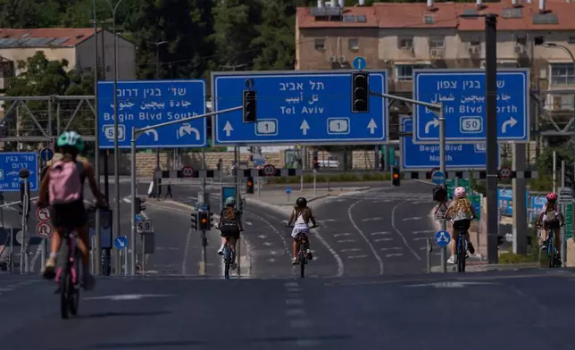 Girls ride their bicycles on a car-free road during the Jewish holiday of Yom Kippur, in Jerusalem, Monday, Sept. 21, 2026. (AP Photo/Ohad Zwigenberg)