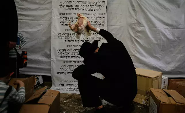 An ultra-Orthodox Jewish man swings a chicken over his head as part of the Kaparot ritual ahead of the Jewish holiday of Yom Kippur in Jerusalem, Thursday, Sept. 17, 2026. (AP Photo/Ohad Zwigenberg)