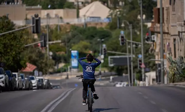 A boy rides his bicycle on a car-free road during the Jewish holiday of Yom Kippur, in Jerusalem, Monday, Sept. 21, 2026. (AP Photo/Ohad Zwigenberg)